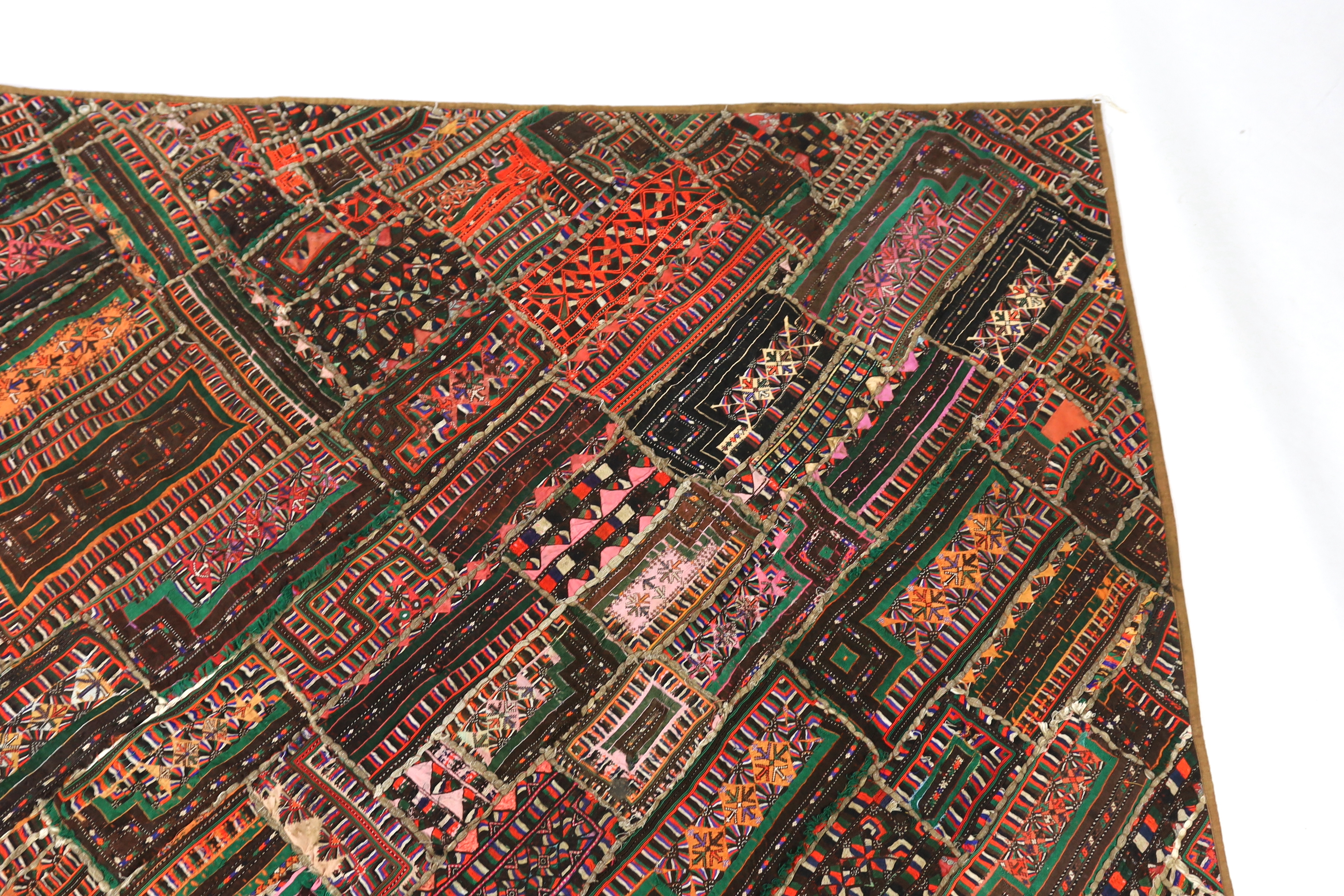 An interesting 20th century North Indian or Tibetan patchworked cover, worked in silk, wool and cotton embroidery in varying colours using thick bundles of threads to border / outline the patchwork, this has possibly bee